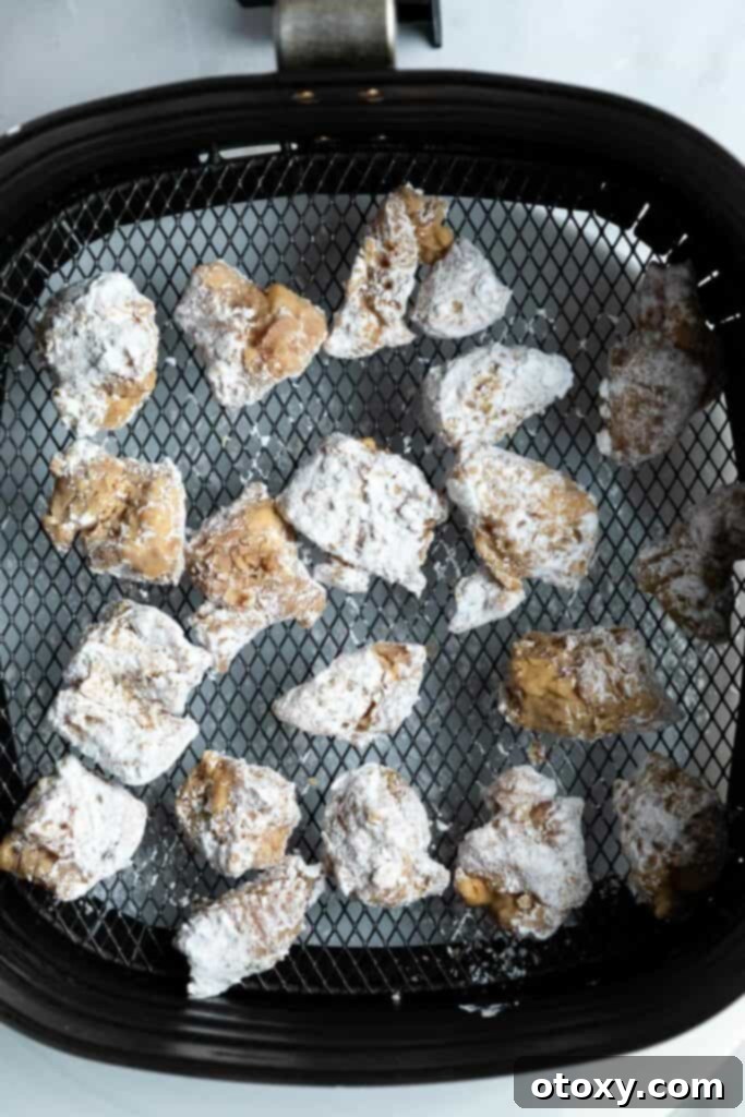 Golden Crispy Air Fryer Karaage 6 raw chicken pieces in an air fryer basket ready to be cooked.