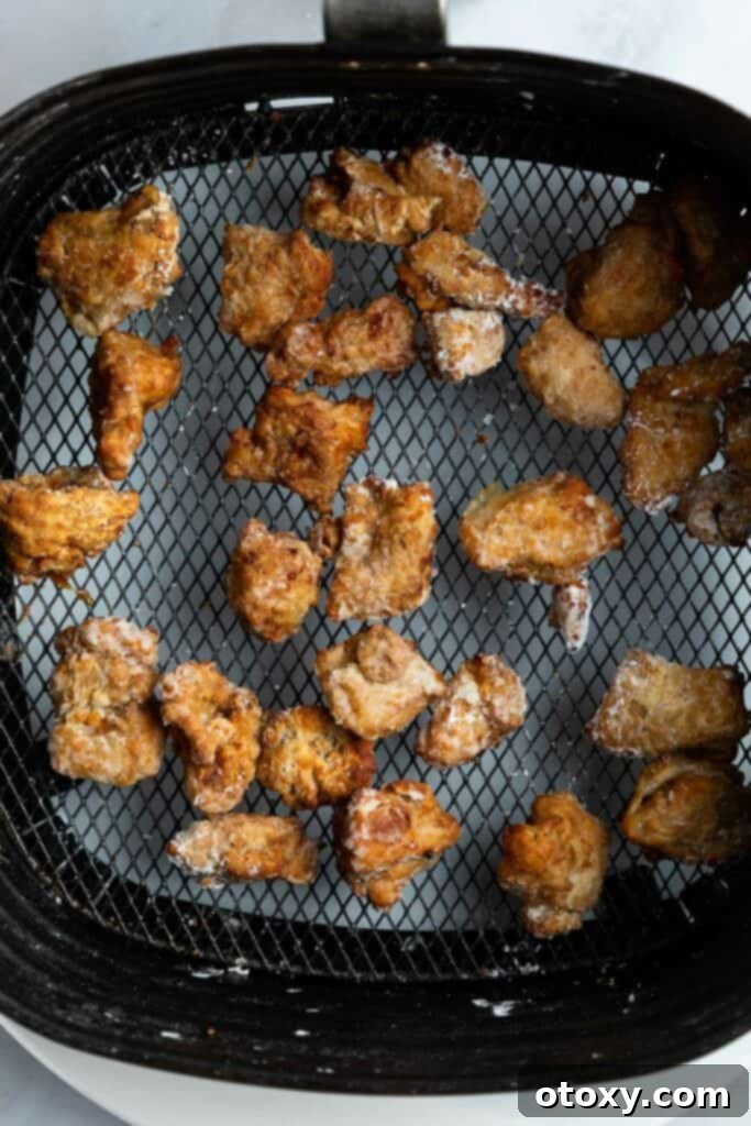 Golden Crispy Air Fryer Karaage 7 karaage chicken in an air fryer basket.