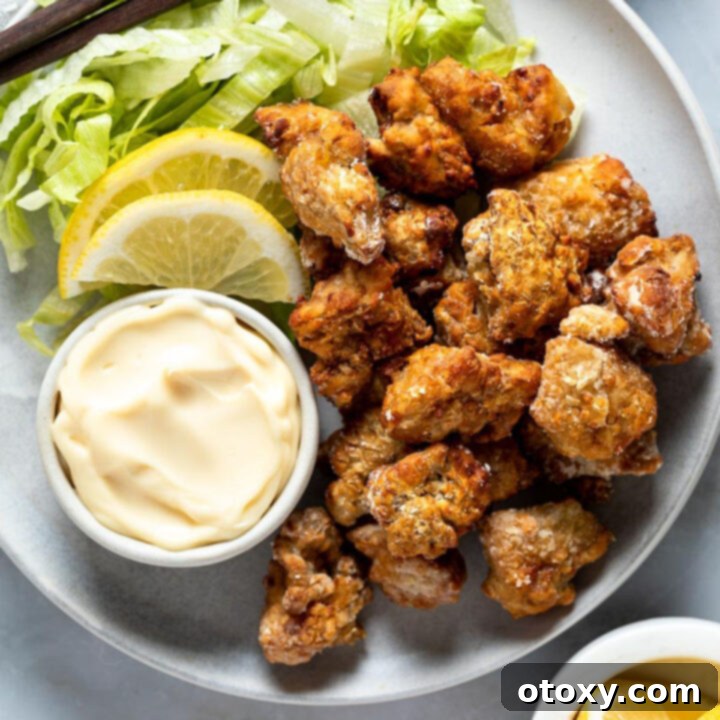 Golden Crispy Air Fryer Karaage 10 pieces of karaage chicken on a plate with mayonnaise and lemon slices.