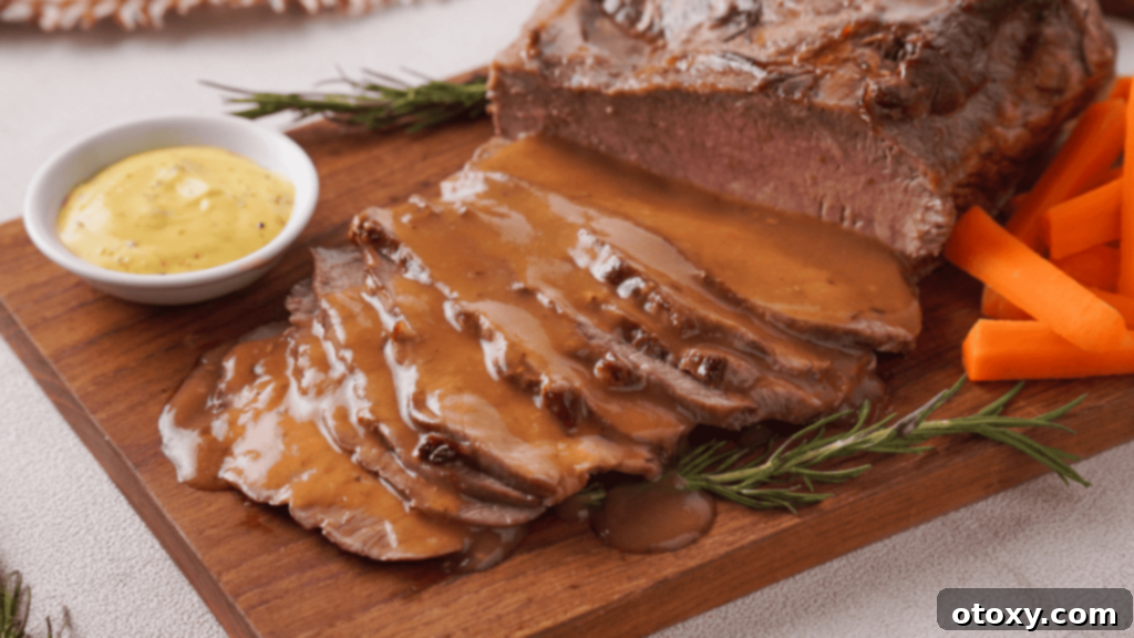 Perfect Air Fryer Roast Beef 2 Roast Beef with veggies, gravy and mustard on a wooden coaster