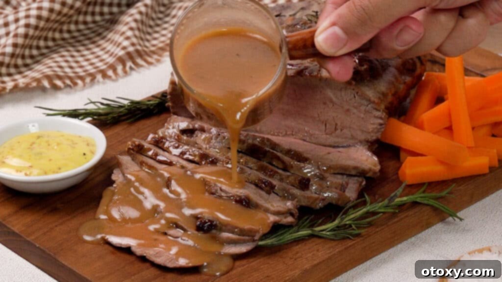 Perfect Air Fryer Roast Beef 16 Air Fryer Roast Beef on a wooden coaster poured with gravy