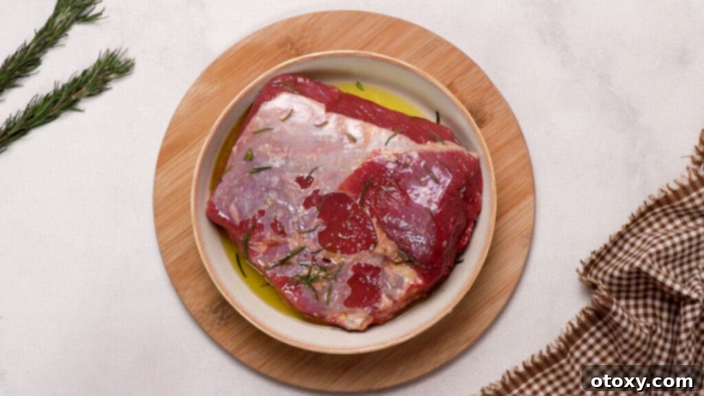 Perfect Air Fryer Roast Beef 9 The beef on the plate is mixed with the oil-herb mixture