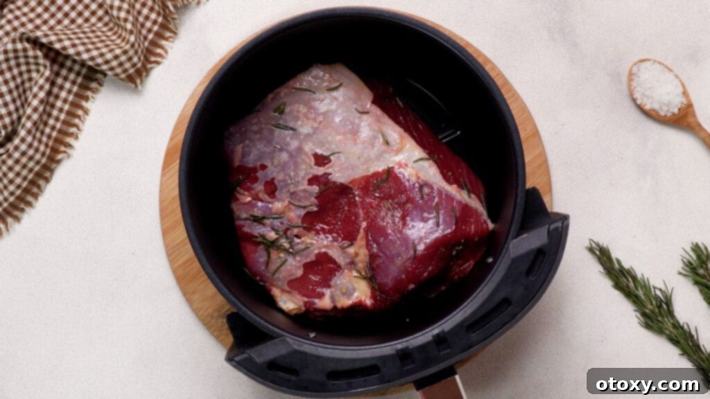 Perfect Air Fryer Roast Beef 10 Beef seasoned with oil-herb mixture in the ninja air fryer basket