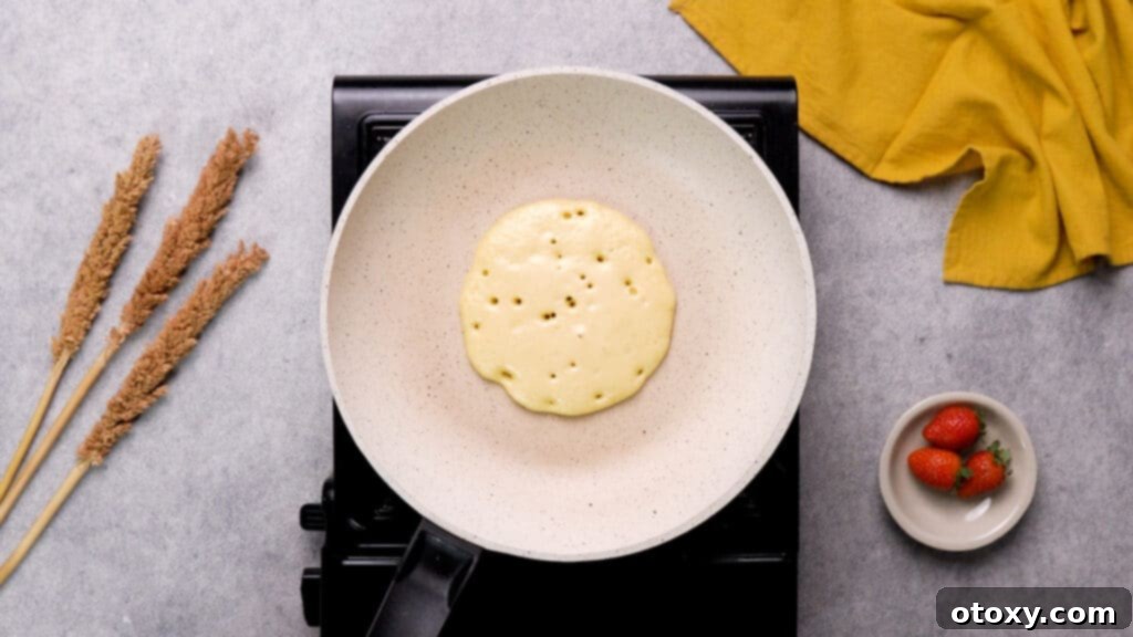 Ultimate 40g Protein Pancakes 9 Protein pancakes with tiny bubbles on non-stick pan