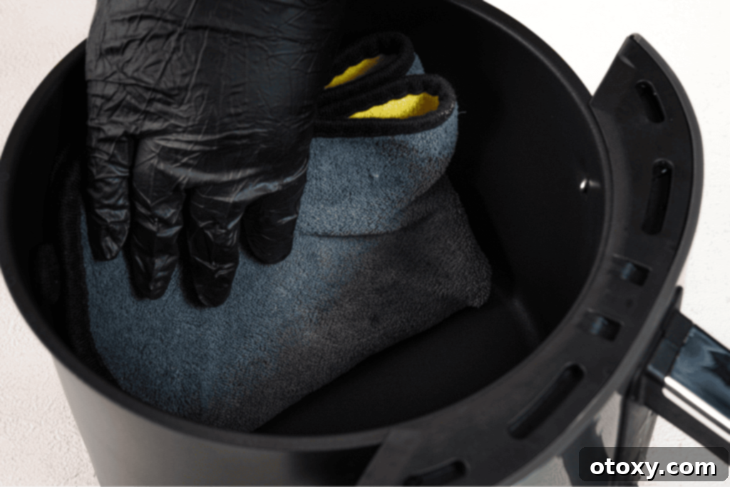 Cleaning air fryer basket with microfiber cloth