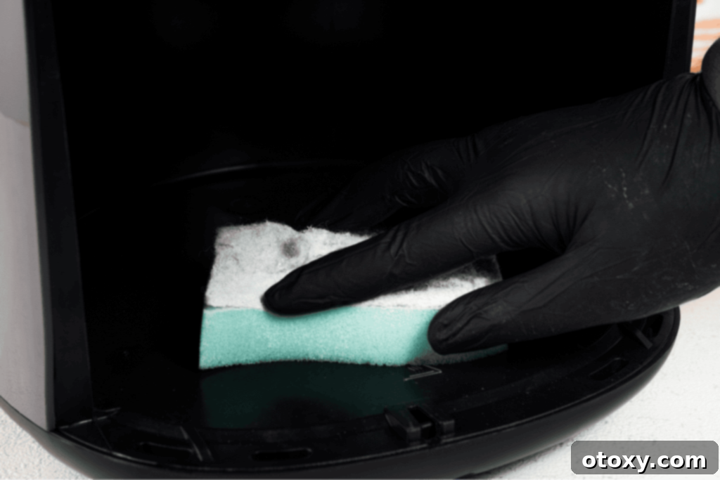 Cleaning air fryer interior with sponge
