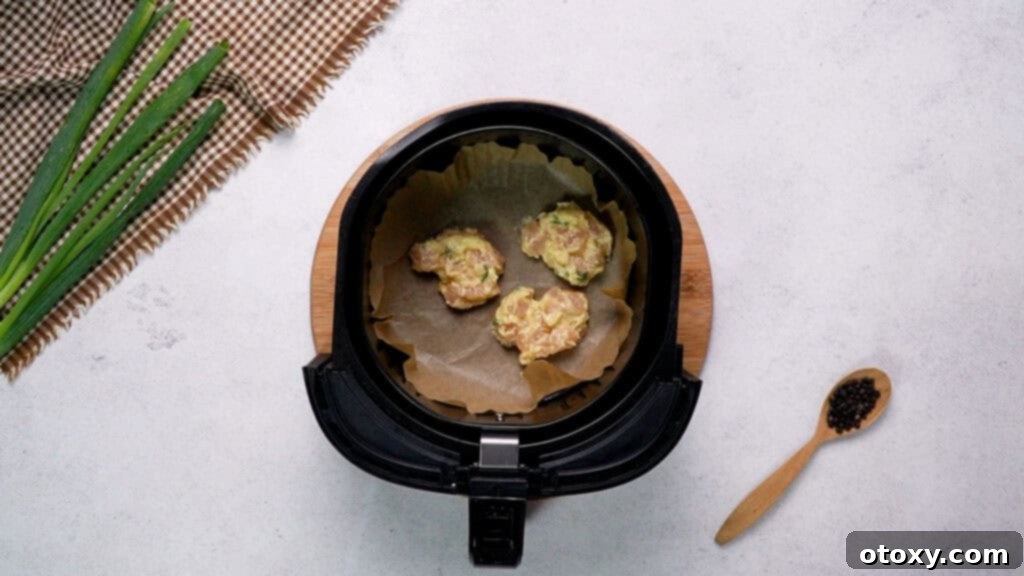 Crispy Chicken Delights 14 Chicken fritter patties arranged in a single layer inside an air fryer basket, ready for cooking.