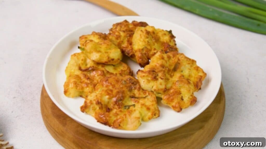 Crispy Chicken Delights 16 Air-fried chicken fritters neatly arranged on a white plate, showcasing their light golden-brown and crispy texture.