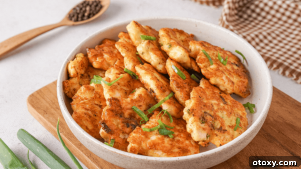 Crispy Chicken Delights 17 An elegantly styled plate of chicken fritters, artfully arranged and garnished, ready to be served.