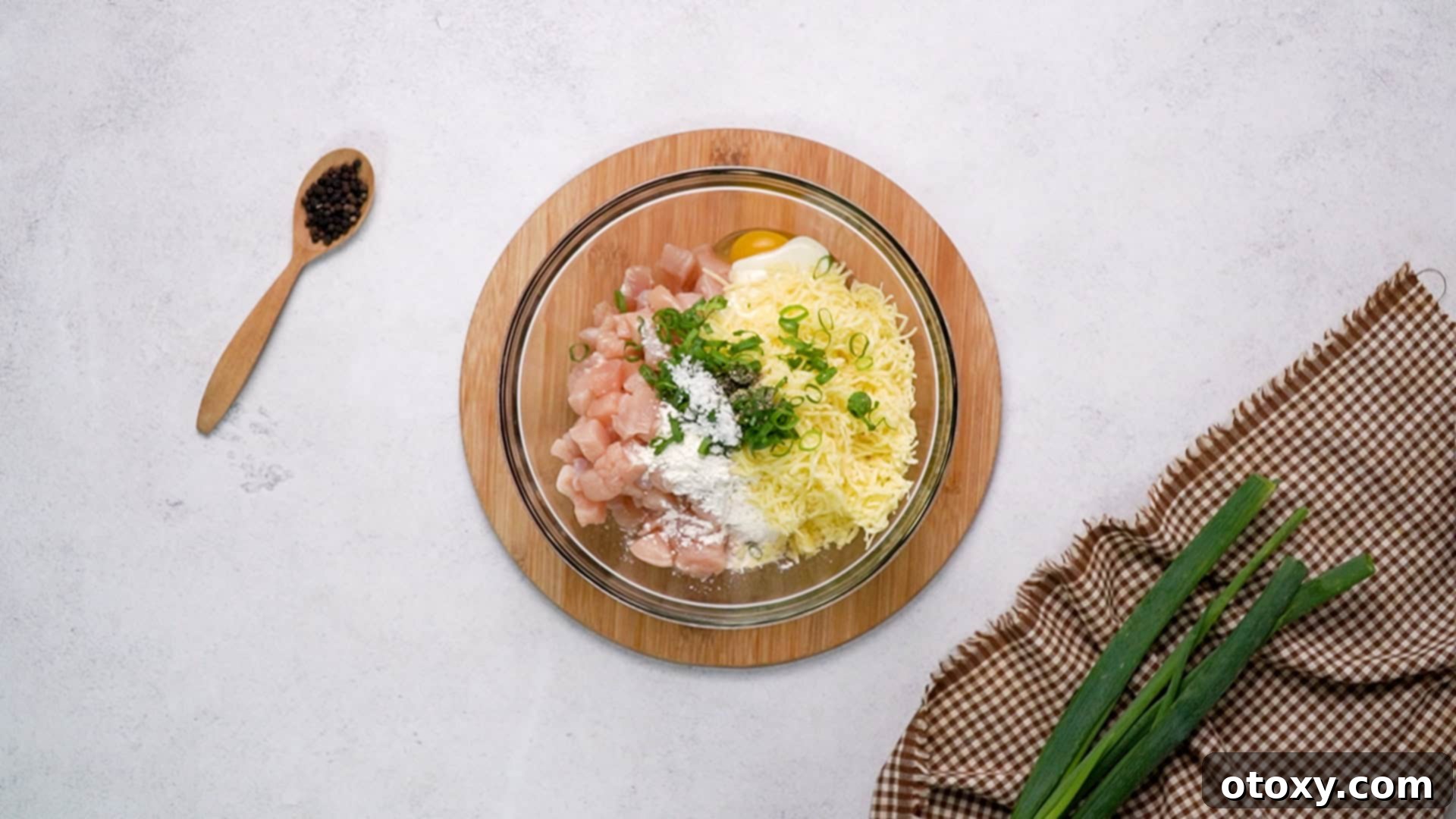 Crispy Chicken Delights 20 All chicken fritter ingredients, including diced chicken, eggs, yogurt, flour, cheese, and seasonings, are placed together in a large mixing bowl.