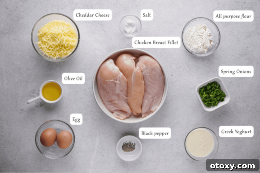 Crispy Chicken Delights 4 A flat lay photograph showcasing all the fresh ingredients needed for chicken fritters, including diced chicken, eggs, yogurt, flour, cheese, and spring onion.