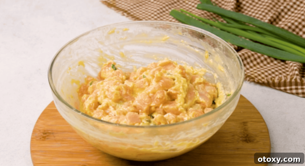Crispy Chicken Delights 7 A close-up view of the chicken fritter mixture in a mixing bowl, showing the even distribution of ingredients.