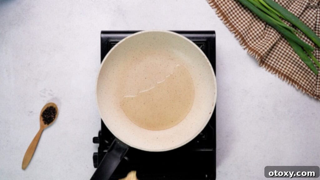 Crispy Chicken Delights 9 Olive oil heating in a non-stick frying pan over medium heat.