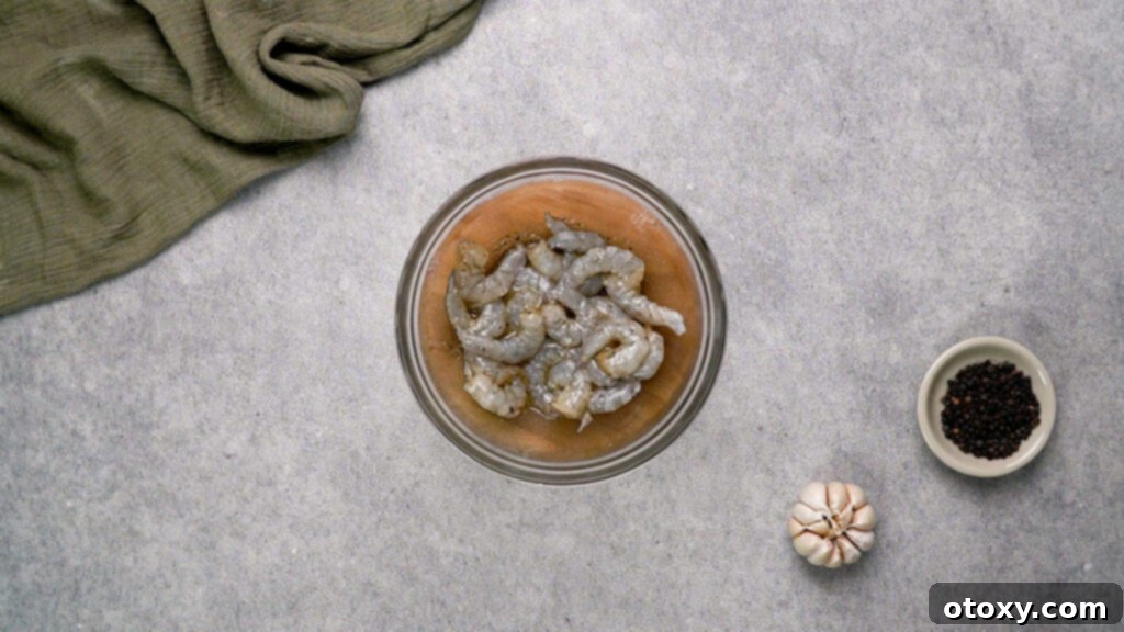 Shrimp being tossed in mixing bowl with seasoning