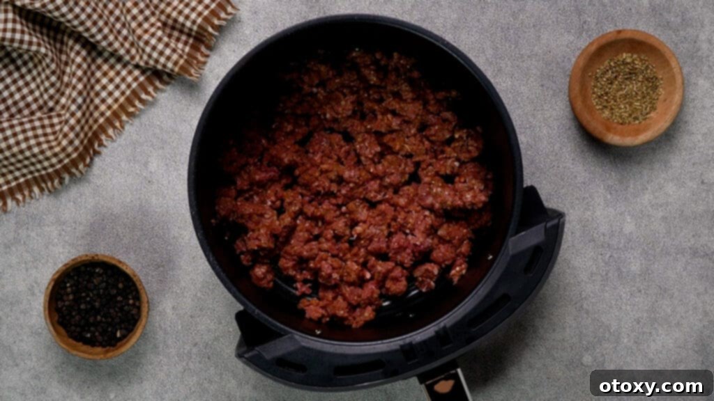 Effortless Air Fryer Ground Beef 9 Seasoned ground beef spread evenly in an air fryer basket
