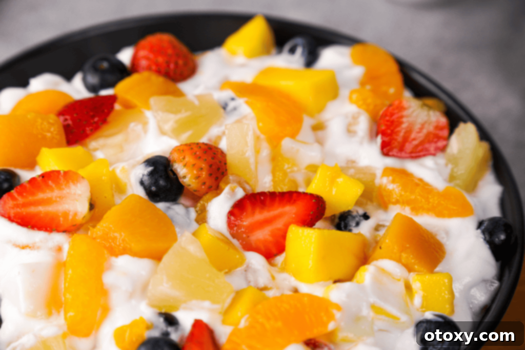 A different variation of fruit salad with Cool Whip, possibly with different fruits or toppings, served in a bowl.
