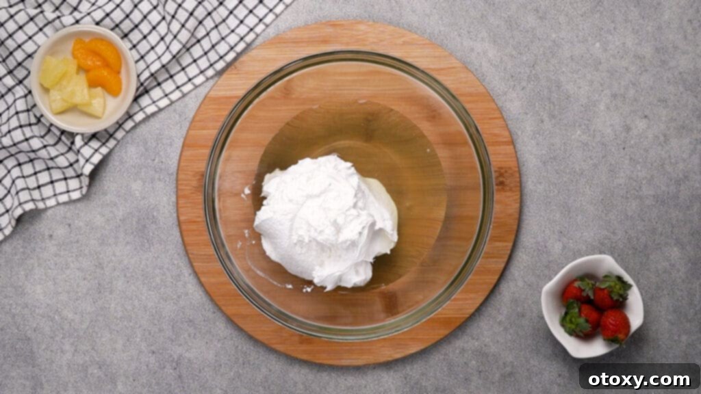 Step 1: Combining pineapple juice, peach juice, and Cool Whip in a large mixing bowl.
