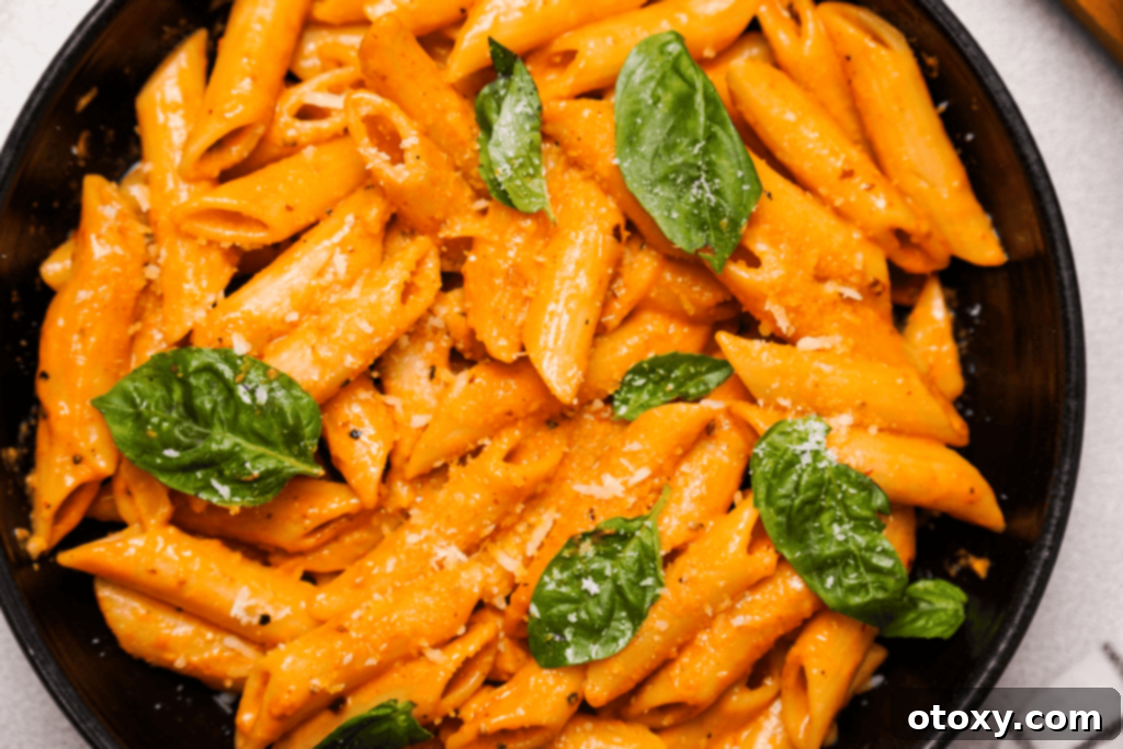 Gigi Hadid Pasta close-up, showcasing the creamy sauce clinging to the pasta with hints of red chili flakes and fresh basil.