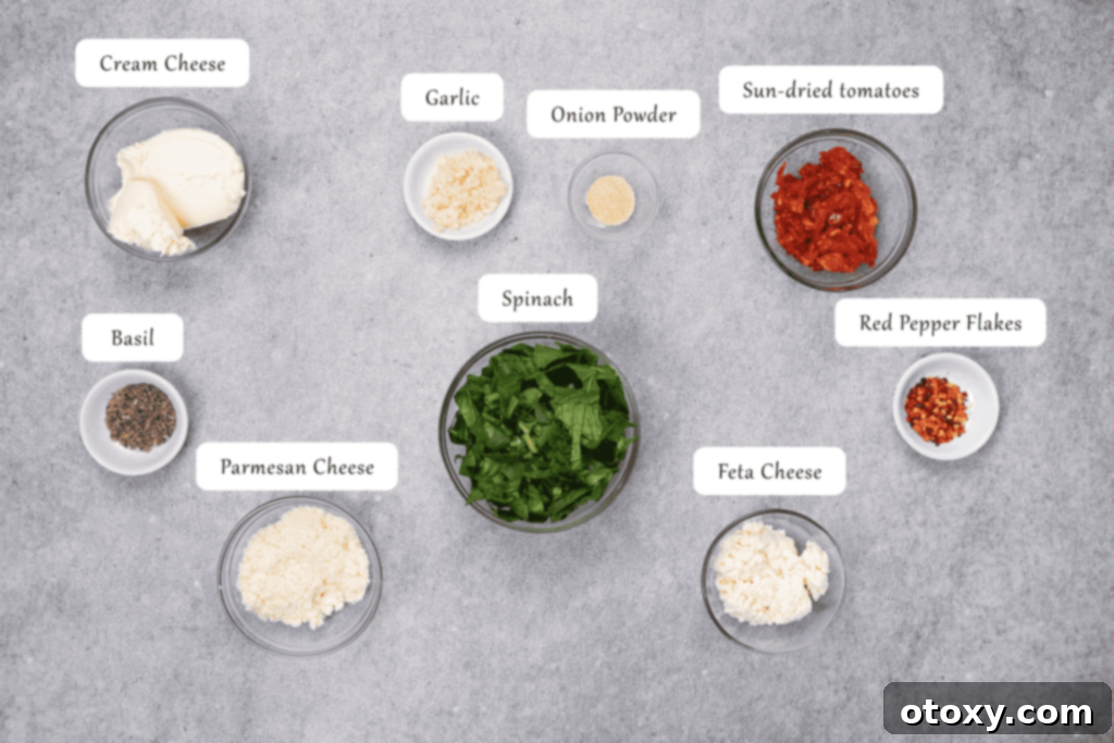 A vibrant collection of filling ingredients: cream cheese, fresh spinach, garlic, sun-dried tomatoes, feta, Parmesan, basil, onion powder, and red pepper flakes.