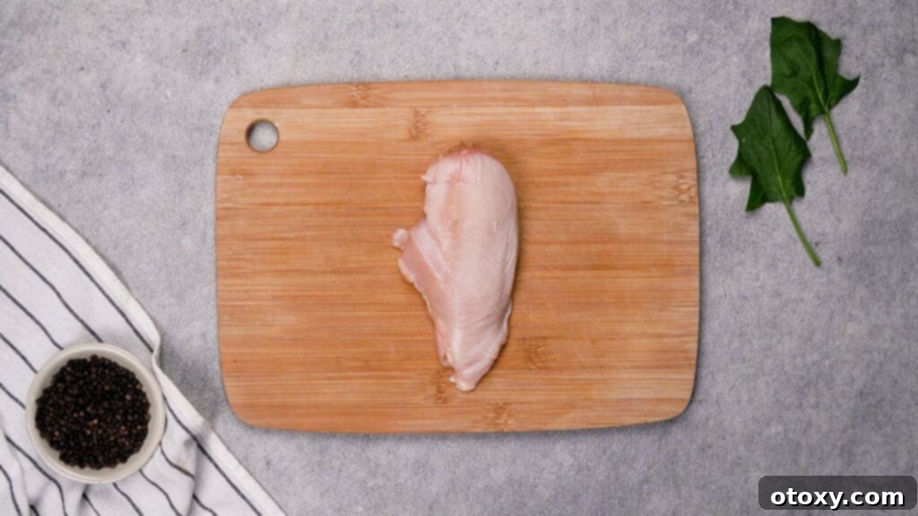 Butterflying a chicken breast, slicing horizontally to create a pocket.