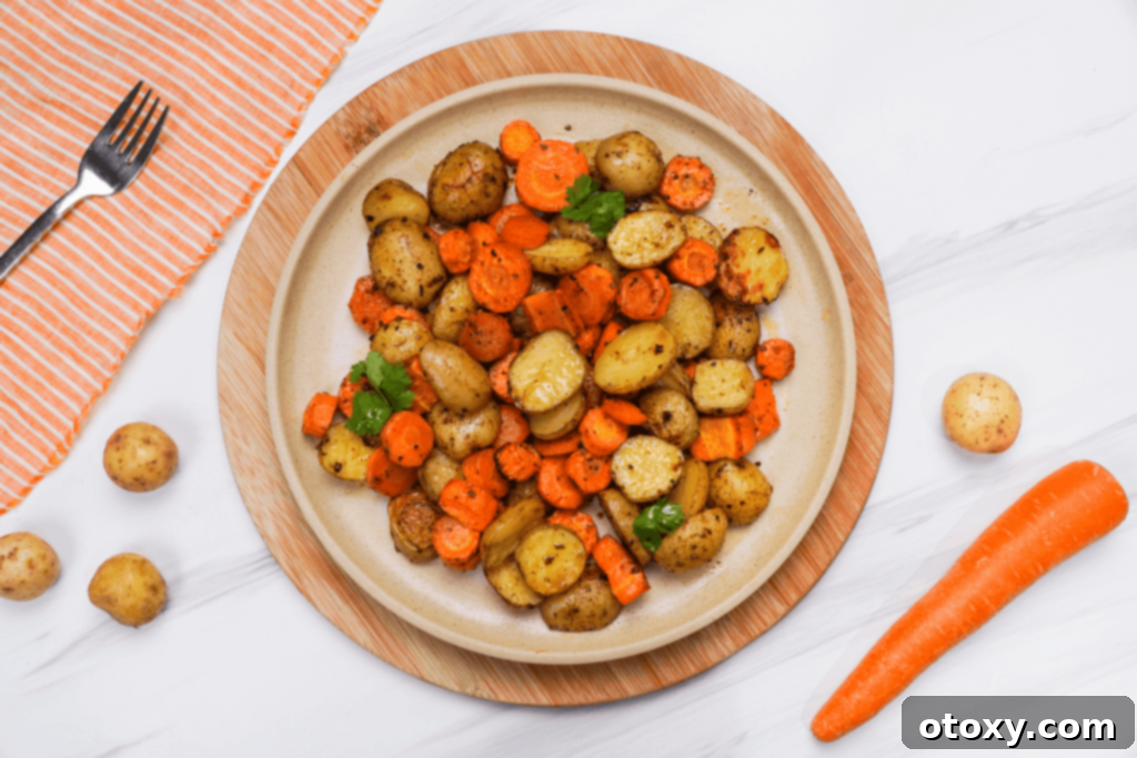 Herb Roasted Potatoes and Carrots 3 Appetizing roasted potatoes and carrots served on a white plate