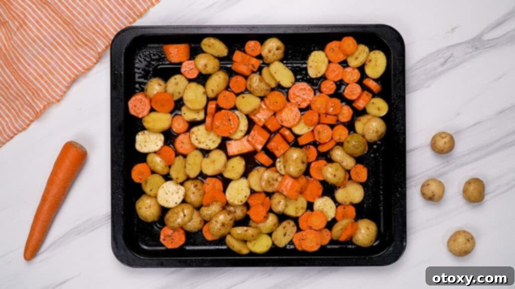 Herb Roasted Potatoes and Carrots 9 Seasoned potatoes and carrots spread in a single layer on a baking sheet