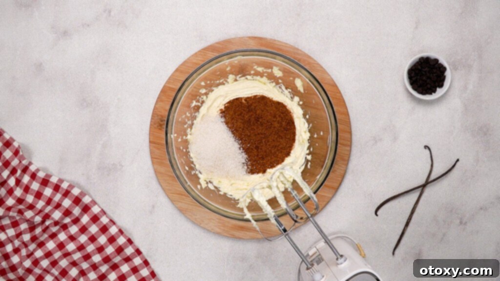 Brown sugar and granulated sugar being mixed with butter