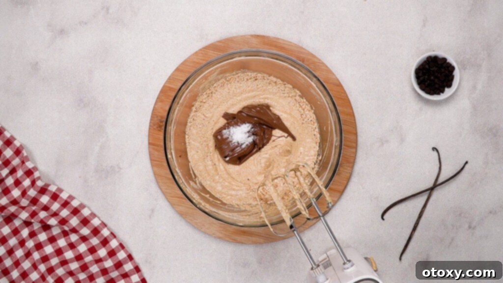 Nutella and salt being mixed into brownie batter