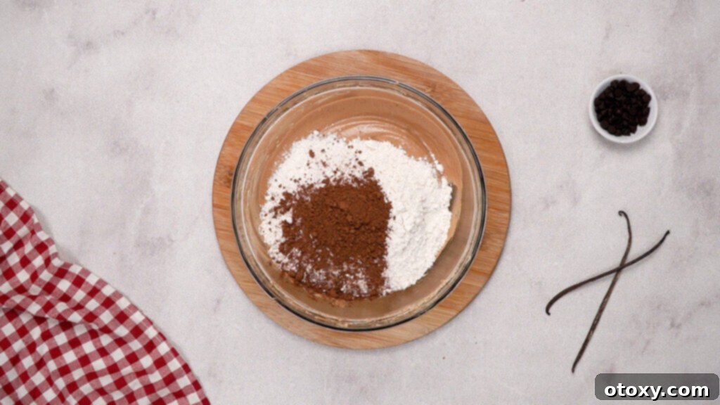 Flour and cocoa powder being gently mixed into brownie batter