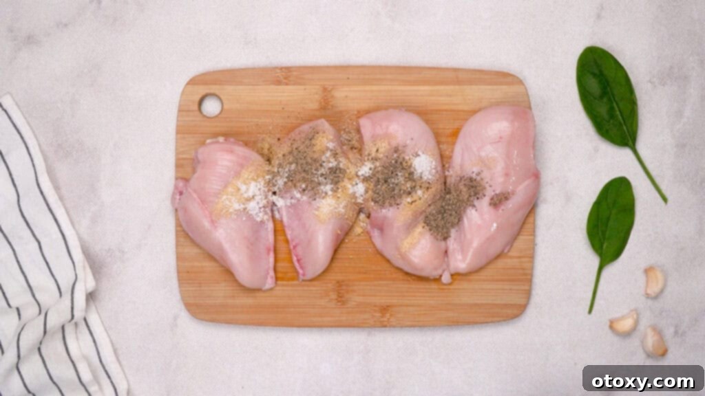 Seasoning chicken cutlets with a mix of garlic powder, onion powder, salt, and pepper