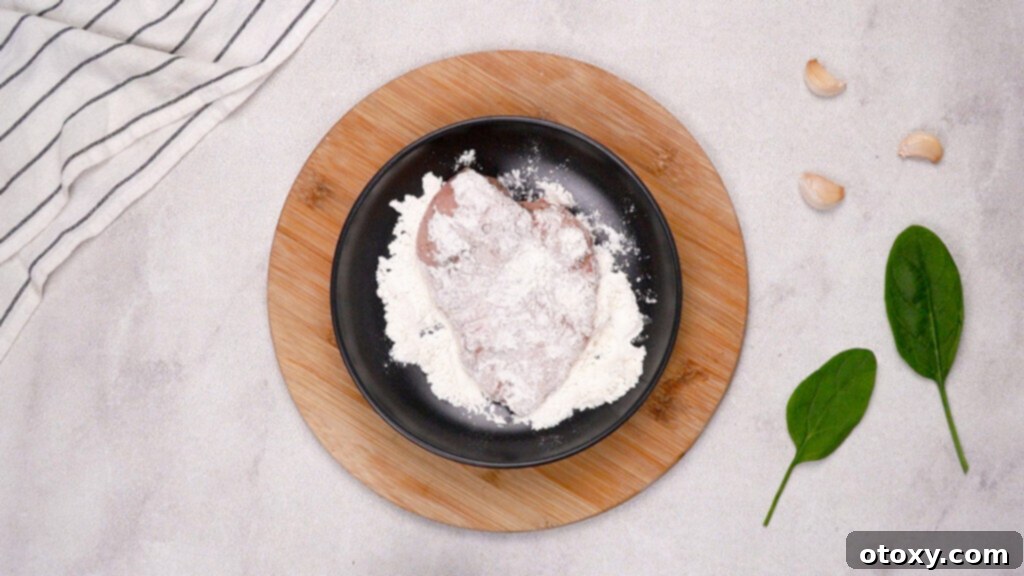 Dredging chicken cutlets in all-purpose flour for a golden crust