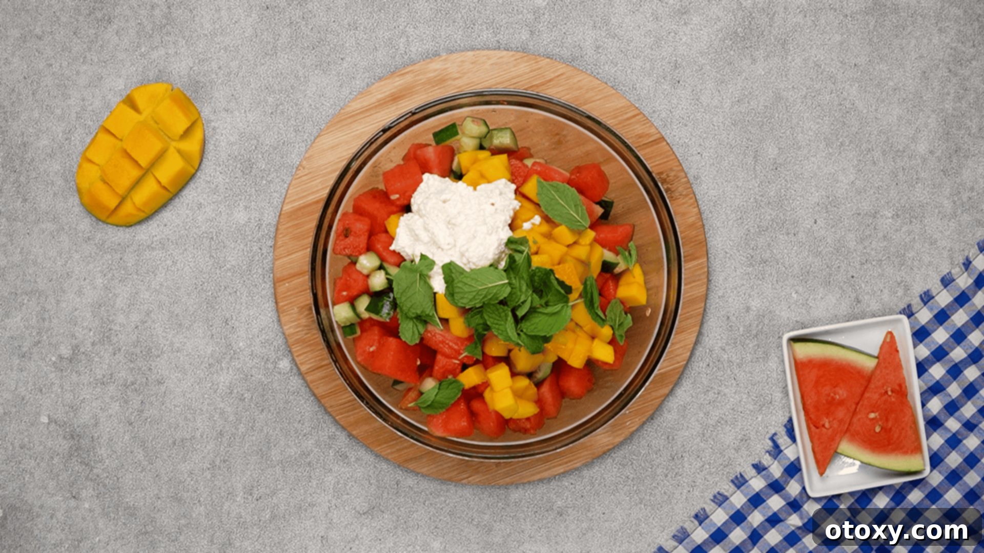 Watermelon Feta Summer Bliss 17 Adding diced mango, crumbled feta, and torn mint leaves to the watermelon and cucumber.