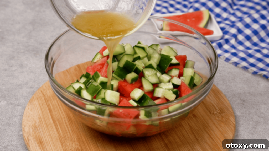 Watermelon Feta Summer Bliss 7 Drizzling honey lime dressing over watermelon and cucumber on a platter.