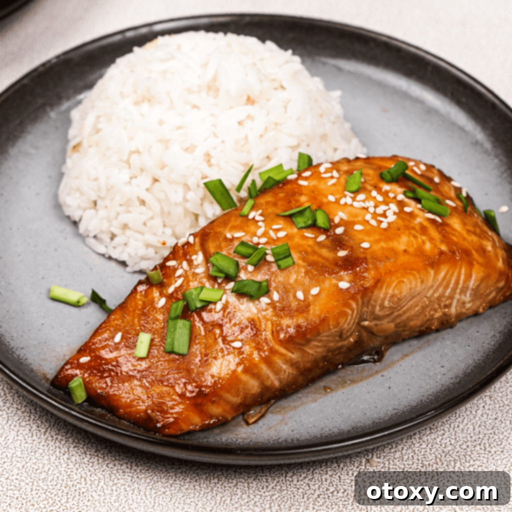 Perfectly cooked miso salmon with rice, garnished with green onions and sesame seeds