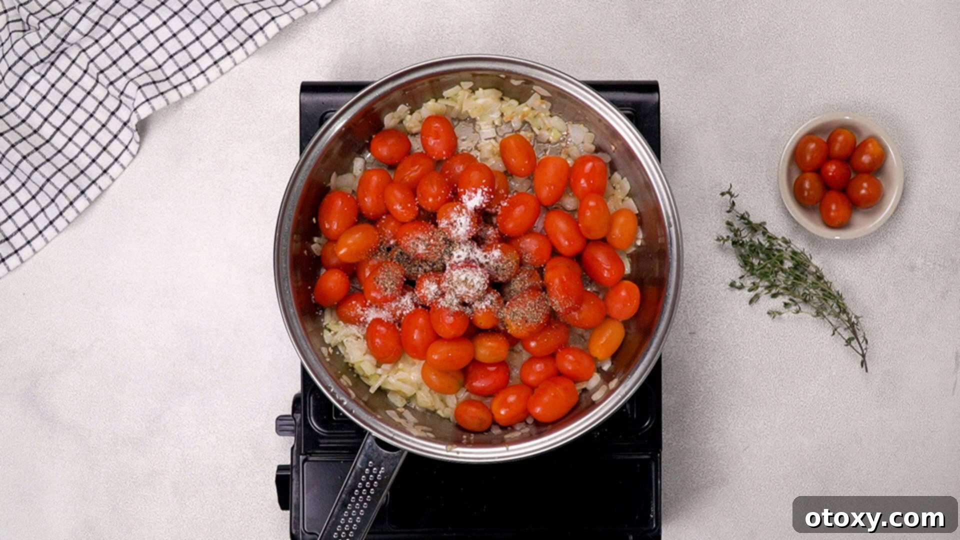 Adding cherry tomatoes and seasonings to the pan