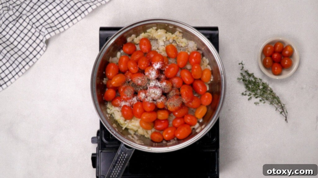 Adding cherry tomatoes and spices to the pan for simmering