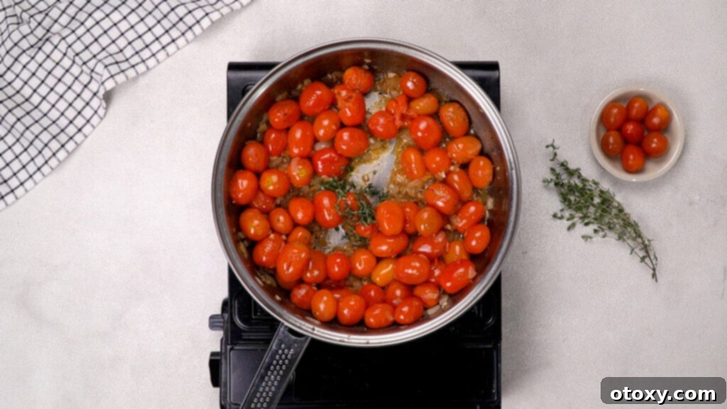 Cherry tomatoes bursting and simmering in the sauce