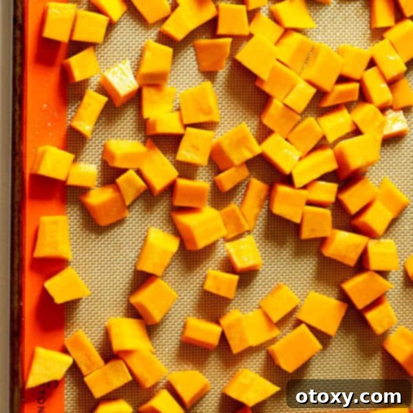 diced pumpkin on a baking tray, ready for roasting