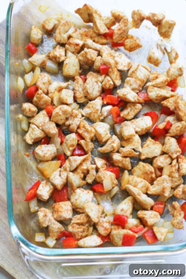 Cooked chicken, bell pepper, and onion on a baking tray, perfectly browned and ready to be served.
