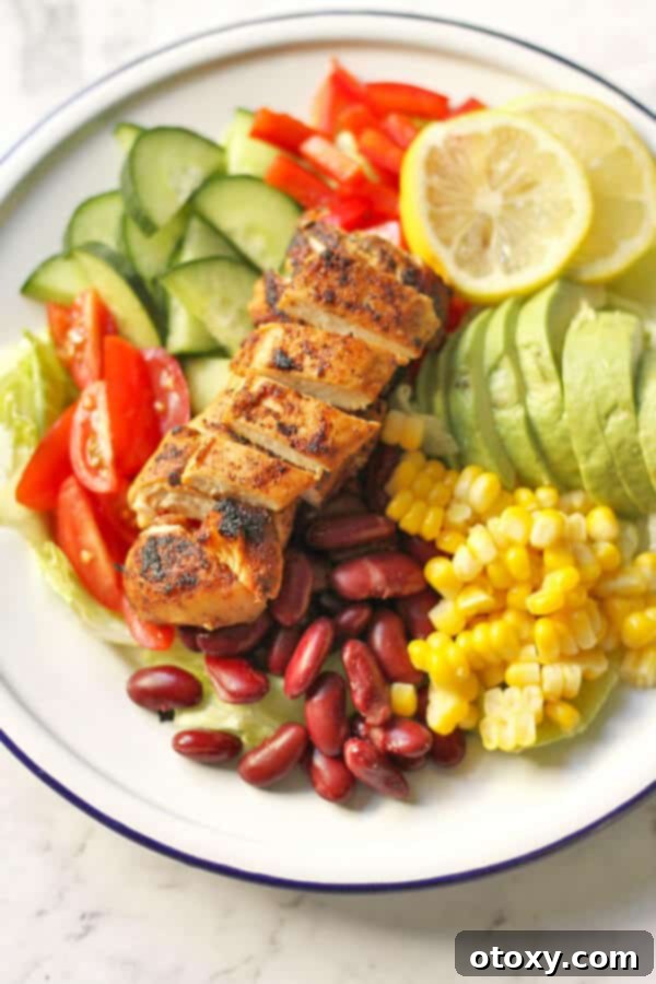 Fiesta Chicken Salad 3 Close-up view of Mexican Chicken Salad, highlighting the texture of grilled chicken, vibrant corn, red kidney beans, and fresh greens, drizzled with dressing.