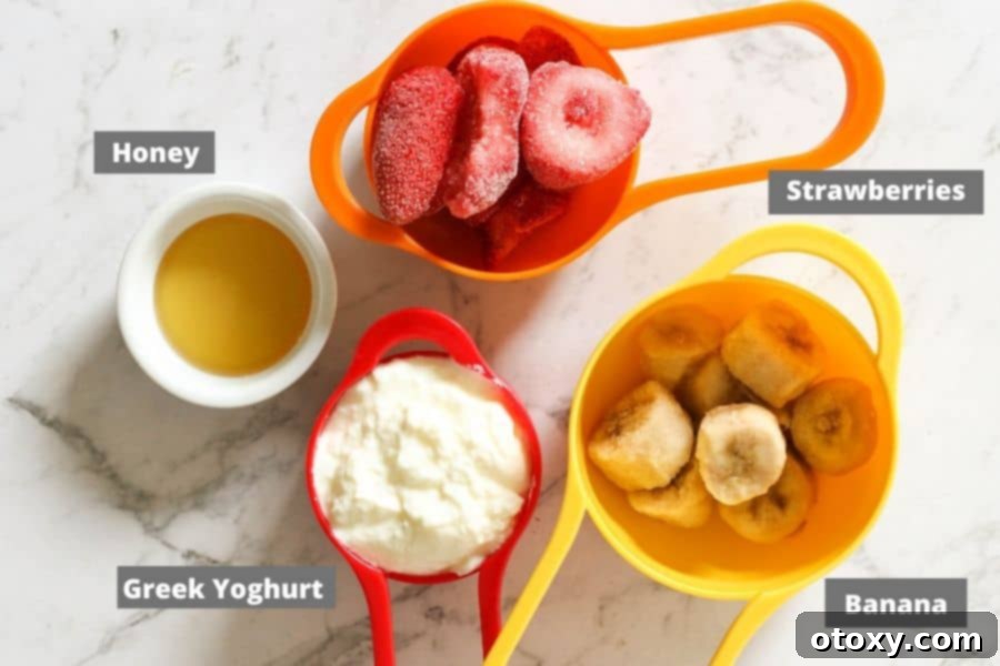 A beautifully arranged selection of strawberry banana popsicle ingredients on a pristine white marble background, highlighting their fresh and natural appeal.