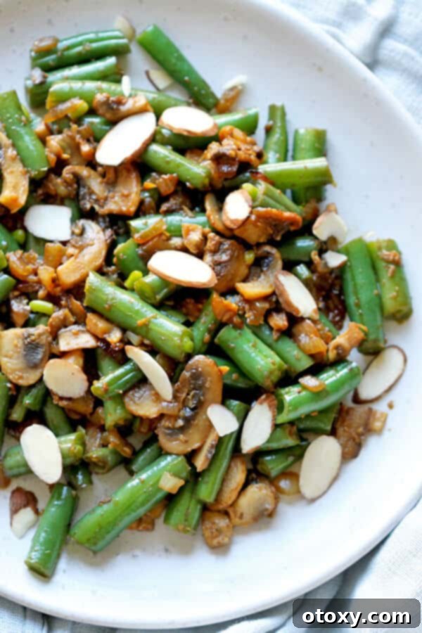 Vibrant Green Bean and Mushroom Sauté 4 sautéed green beans and mushrooms on a white plate