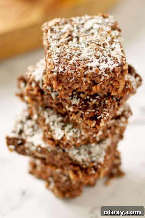 Stacked slices of healthy no-bake chocolate coconut slice