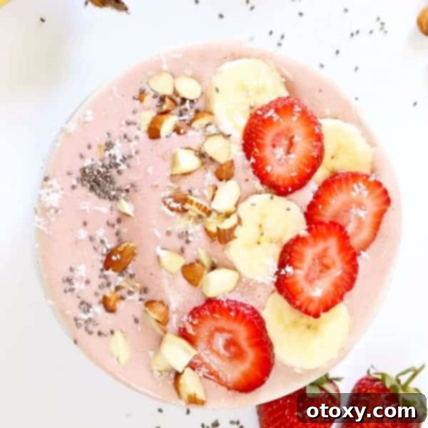 Vibrant Strawberry Banana Smoothie Bowl topped with granola and sliced fruit