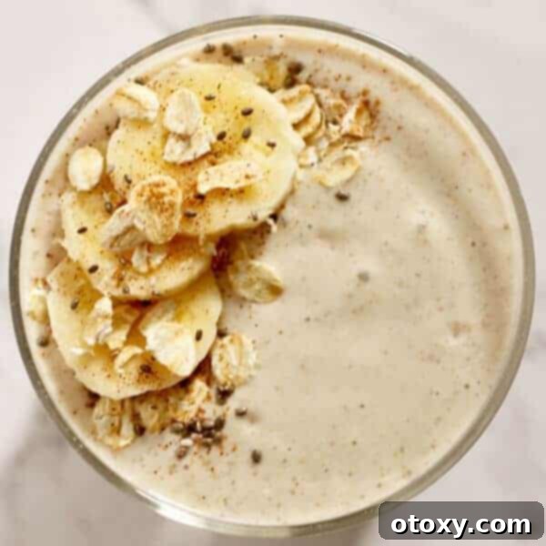 Thick Banana Oat Smoothie in a glass with a straw