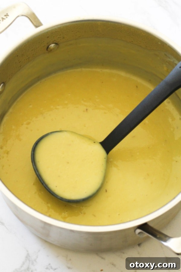 Smooth, puréed Potato and Leek Soup in a saucepan, its creamy texture inviting.