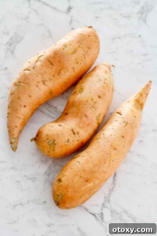 3 sweet potatoes laid on a marble table 
