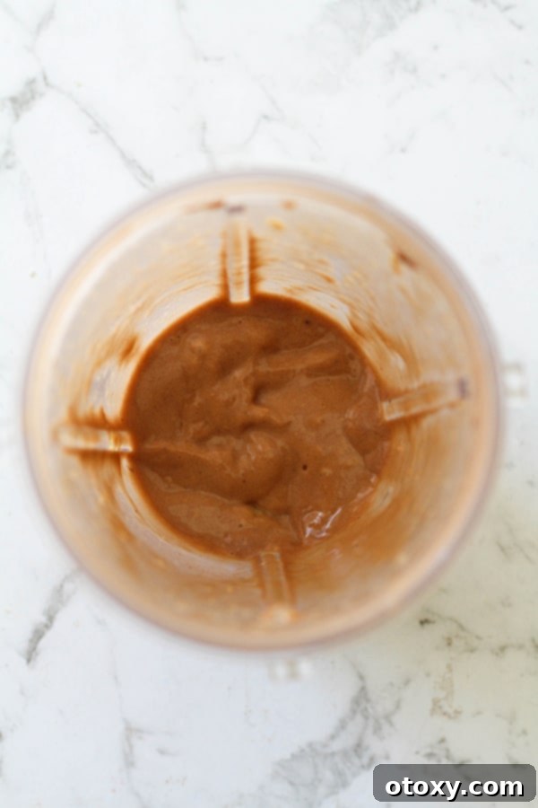 The nice cream blending in the blender cup, showing a smooth and creamy texture forming.