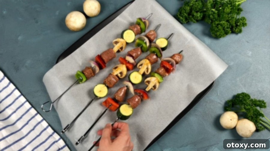 Several sausage and veggie skewers, perfectly threaded and arranged, awaiting their turn on the grill.