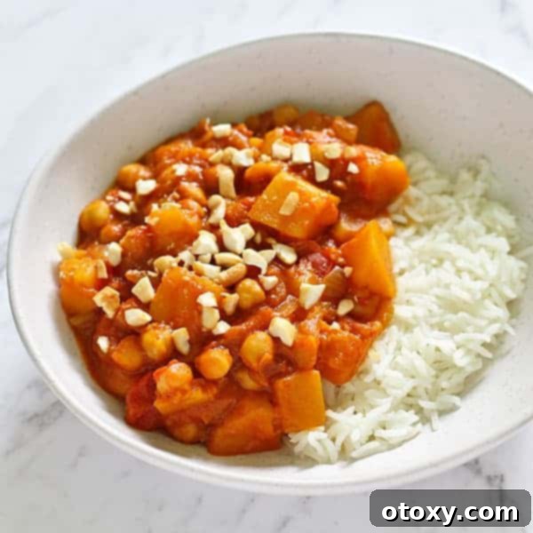 Golden Pumpkin Chickpea Coconut Curry 2 a white bowl filled with pumpkin chickpea curry and rice